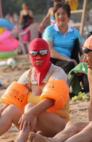 Women balaclava style face masks at a beach, Qingdao, Shandong Province, China - 14 Aug 2014